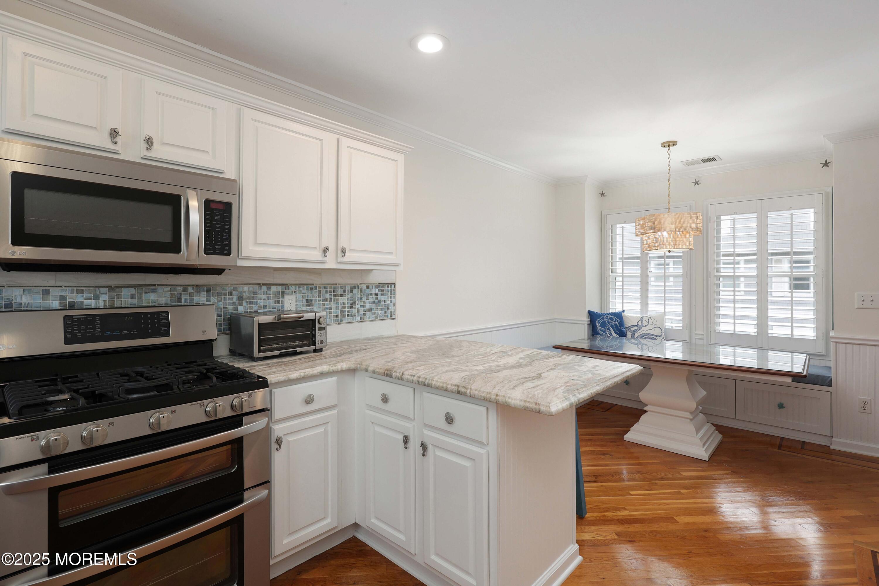 200 2nd Avenue, Unit 14 Belmar, NJ 07719 - Photo 20 of 32 a kitchen with stainless steel appliances granite countertop a stove a sink and a microwave