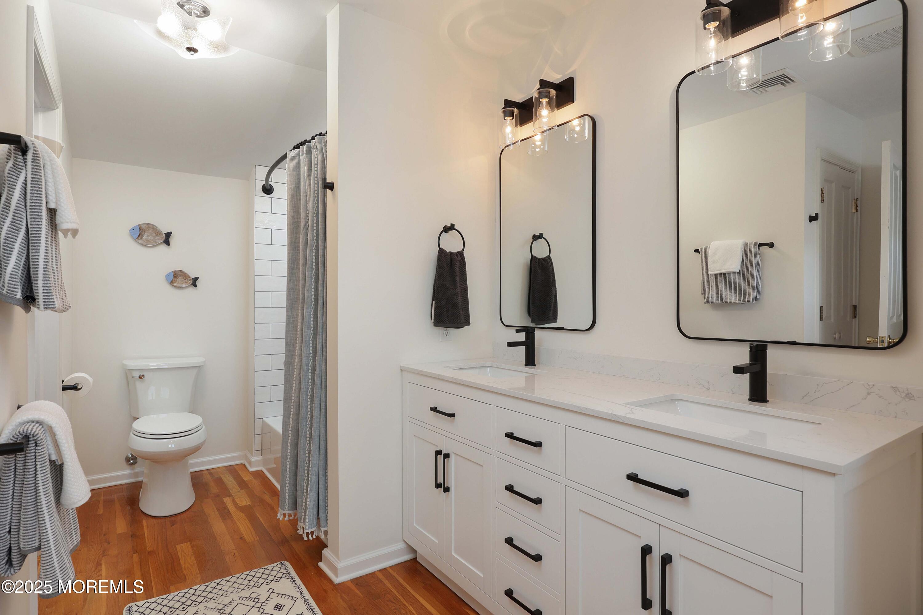 200 2nd Avenue, Unit 14 Belmar, NJ 07719 - Photo 30 of 32 a bathroom with a sink toilet a mirror and shower