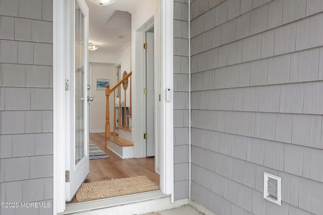 a view of a hallway with wooden floor and staircase