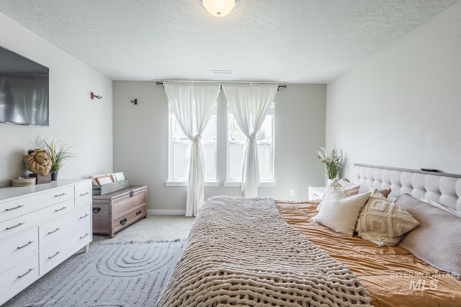 12623 Shadow Peak Street Caldwell, ID 83607 - Photo 29 of 50 Carpeted bedroom featuring light gray walls and a tray ceiling with a flush-mount light fixture