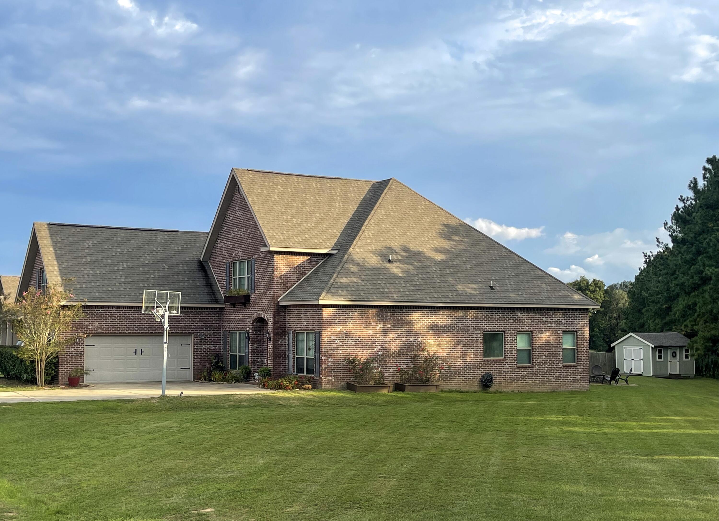 3362 Citrine Circle Crestview, FL 32539 - Photo 2 of 24 a view of a house with a big yard and a large tree