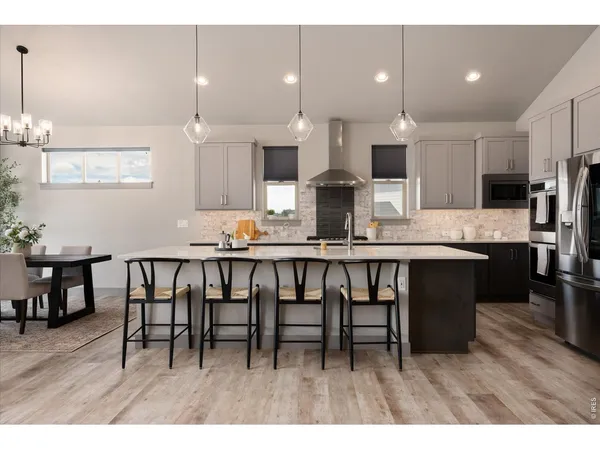 a kitchen with stainless steel appliances kitchen island granite countertop a sink and white cabinets