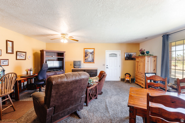 1470 Redwood Tree Street St. George, UT 84790 - Photo 24 of 53 Spacious living area featuring neutral-toned walls, an overhead ceiling fan light fixture, and a white entry door with decorative glass inserts