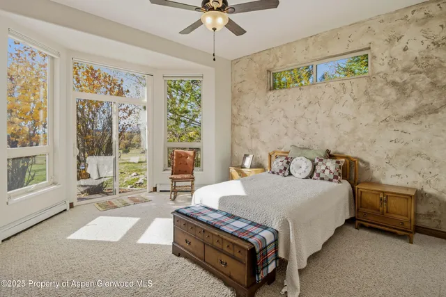 an empty room with windows and ceiling fan