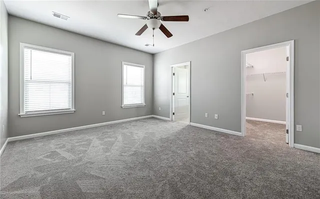 a view of a room with ceiling fan and windows