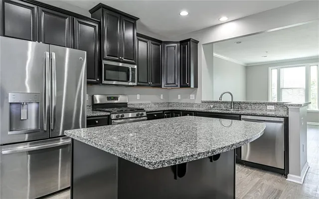 a kitchen with stainless steel appliances granite countertop a sink dishwasher a refrigerator and a stove