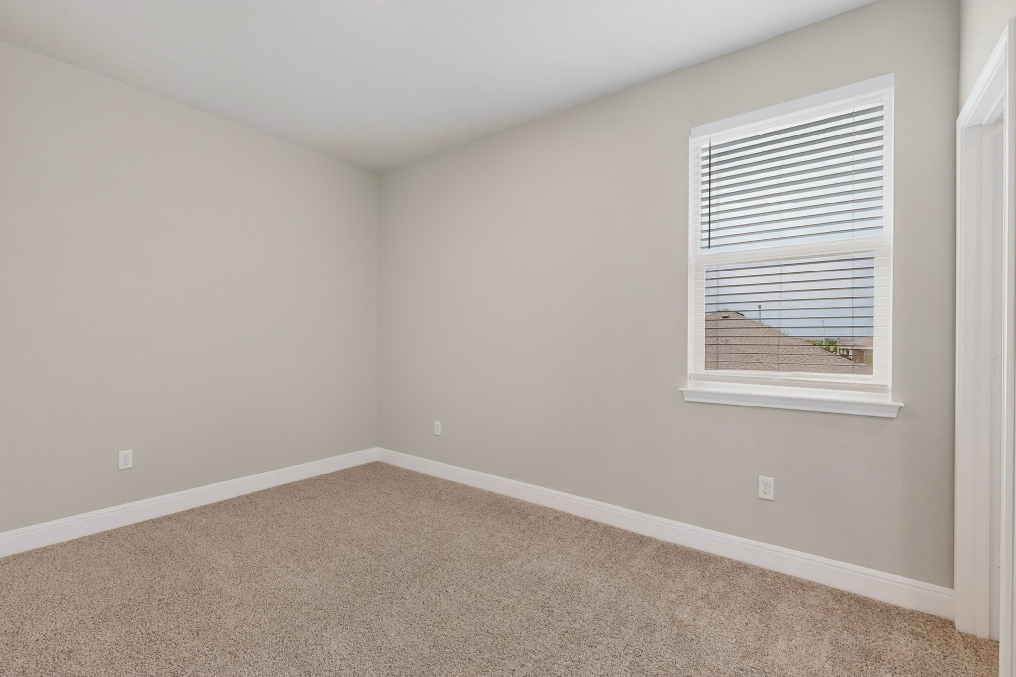 16809 Guido Cove Pflugerville, TX 78660 - Photo 29 of 40 Carpeted room with a single window featuring white blinds, framed by light gray walls and white baseboards