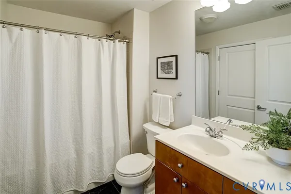 a bathroom with a sink a toilet and shower curtain