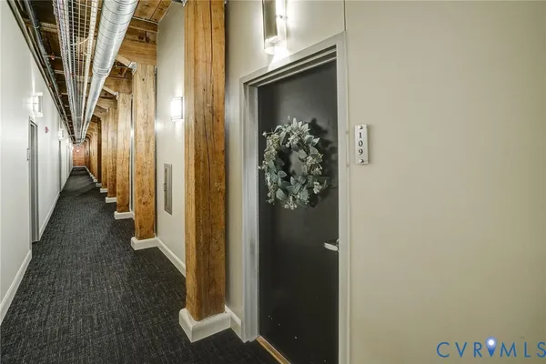 a view of a hallway with wooden floor and staircase