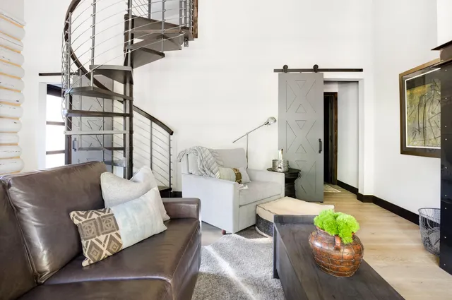 a living room with furniture and a painting on the wall