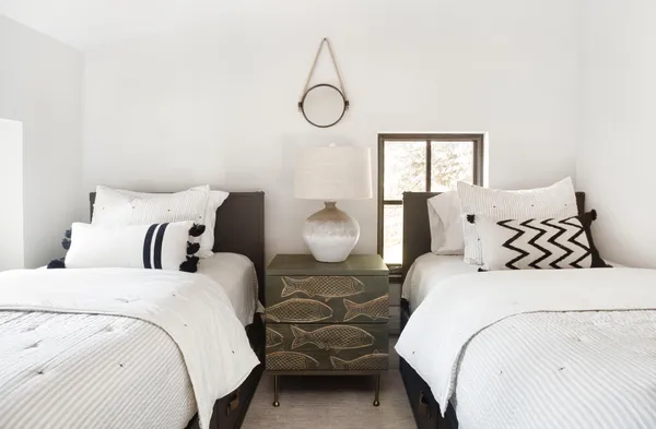 a bedroom with double bed and two window