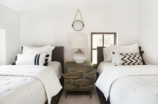 a bedroom with double bed and two window