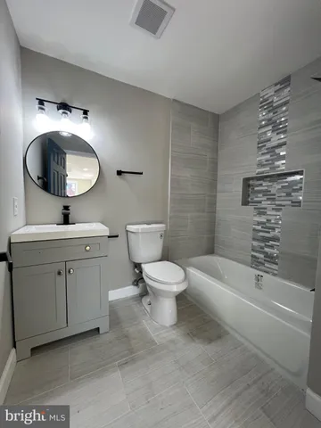 a bathroom with a toilet a sink a mirror and bathtub