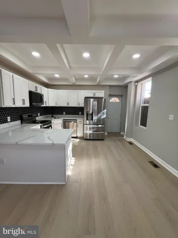 a view of kitchen with stainless steel appliances refrigerator oven stove microwave and cabinets