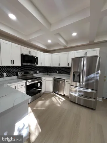 a kitchen with granite countertop a stove top oven and cabinets