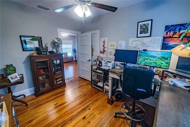 a view of a workspace with furniture and wooden floor