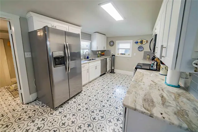 a kitchen with granite countertop a refrigerator and a sink