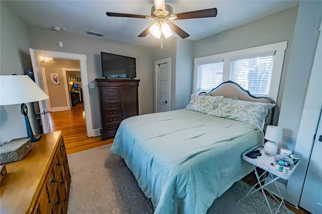 a bedroom with a bed and a flat tv screen on dresser