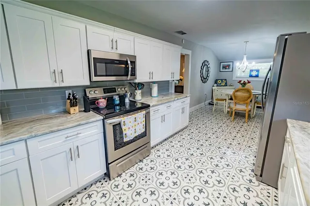 a kitchen with stainless steel appliances a refrigerator a sink a stove a microwave and cabinets