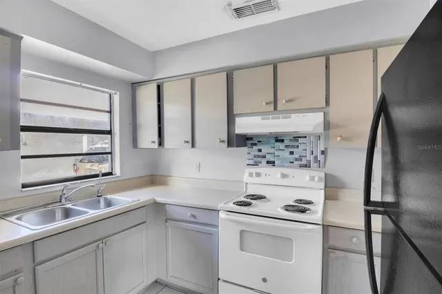 a kitchen with a refrigerator stove and white cabinets