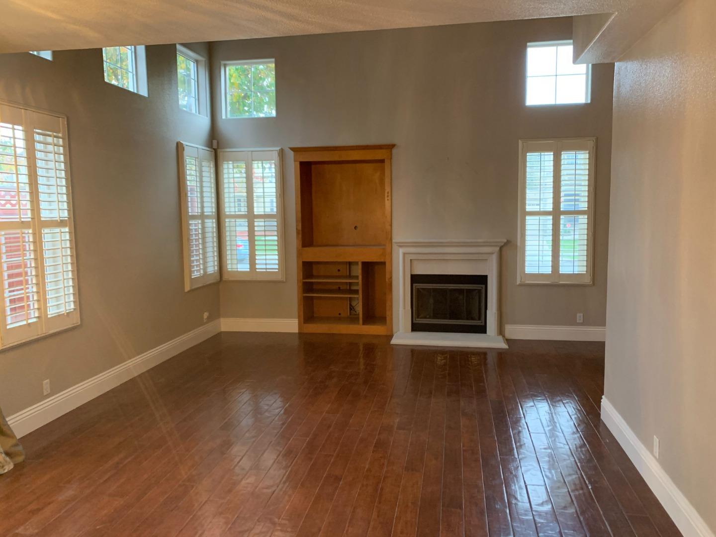 1007 Fitzgerald Street Salinas, CA 93906 - Photo 4 of 22 an empty room with wooden floor fireplace and windows