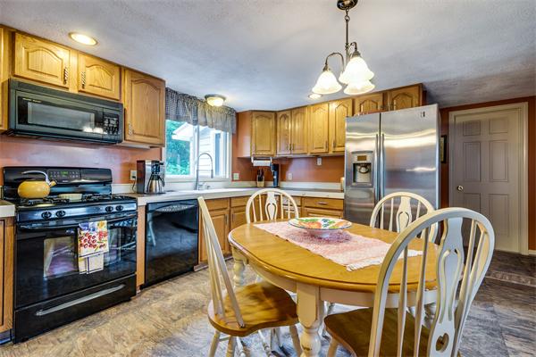 4 Old Providence Road Sutton, MA 01590 - Photo 4 of 30 a kitchen with stainless steel appliances granite countertop a stove top oven a refrigerator a sink a dining table and chairs with wooden floor