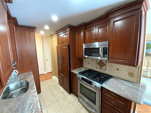 a kitchen with stainless steel appliances granite countertop a refrigerator and a sink