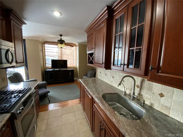 a kitchen with granite countertop a sink stove and refrigerator