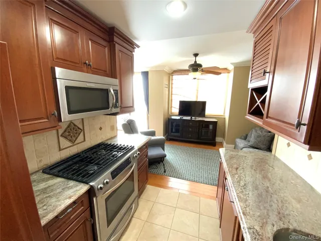 a kitchen with stainless steel appliances granite countertop a stove refrigerator and microwave