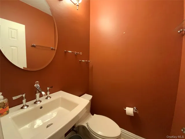 a bathroom with a sink mirror and toilet