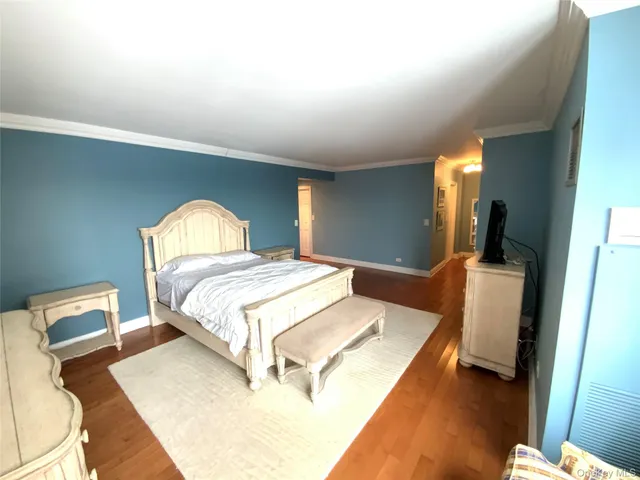 a bedroom with a bed and a dresser with mirror