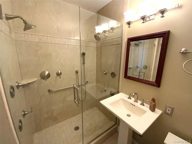 a bathroom with a sink mirror and a shower