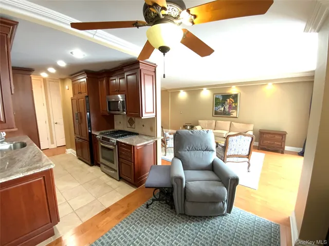 a living room with stainless steel appliances kitchen island granite countertop furniture and a view of kitchen
