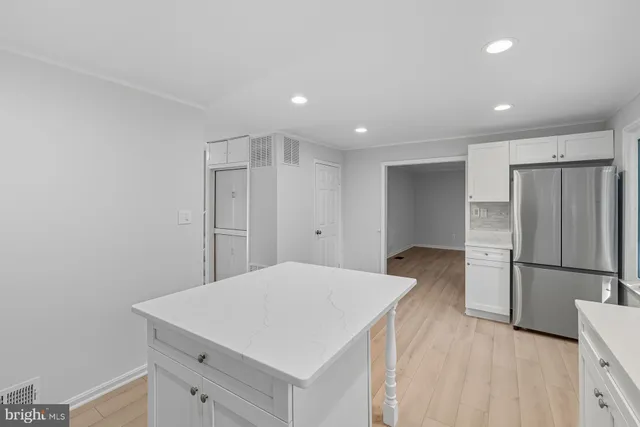 a kitchen with a sink a microwave a refrigerator and white cabinets