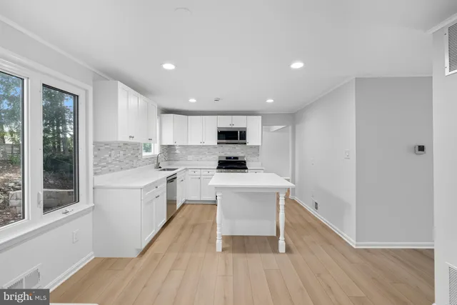 a large white bedroom with bed and large window