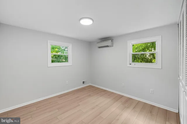 an empty room with wooden floor and window