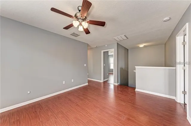 a view of an empty room with wooden floor