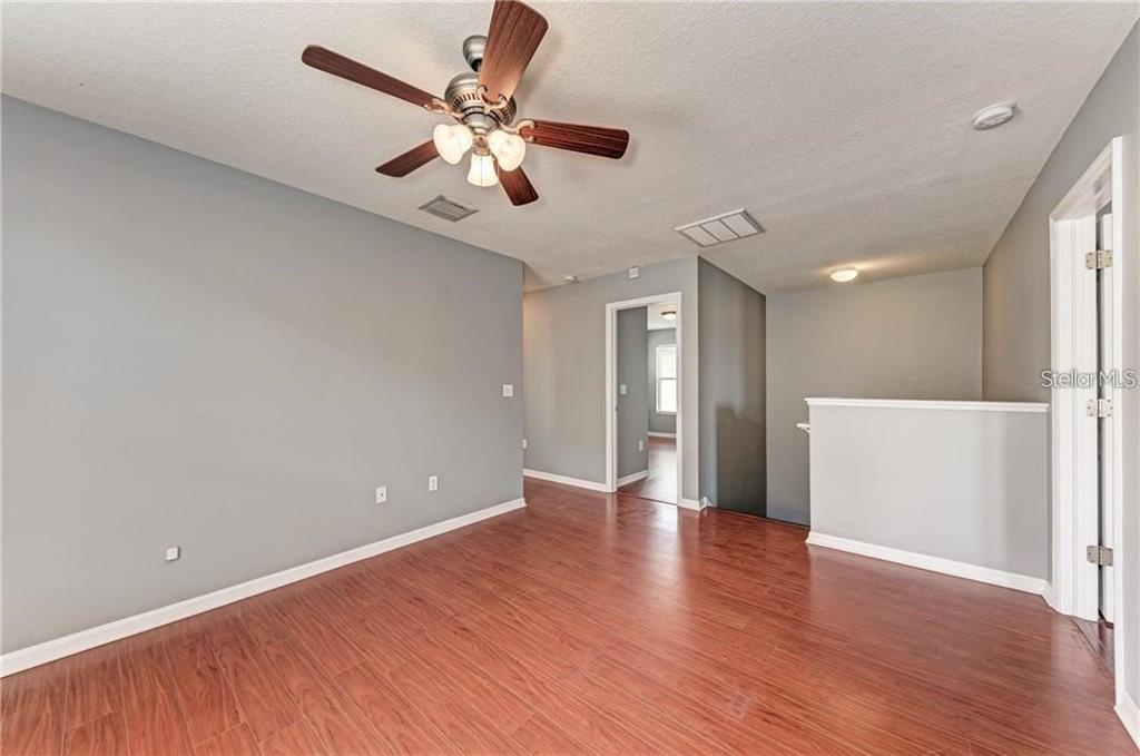 10267 Newminster Loop Ruskin, FL 33573 - Photo 14 of 38 a view of an empty room with wooden floor