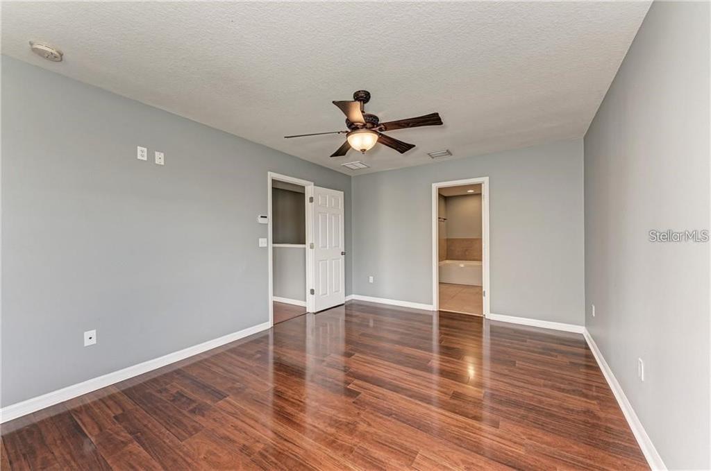 10267 Newminster Loop Ruskin, FL 33573 - Photo 17 of 38 a view of an empty room with wooden floor and a ceiling fan