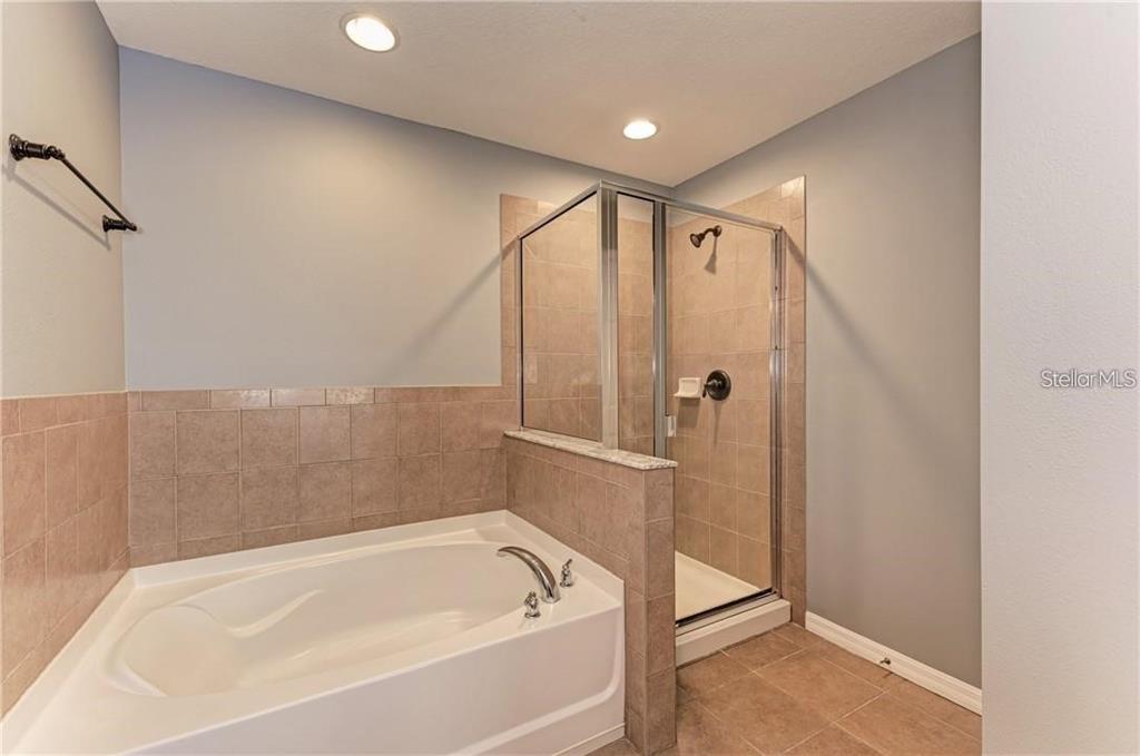 10267 Newminster Loop Ruskin, FL 33573 - Photo 19 of 38 a bathroom with a bathtub and a shower