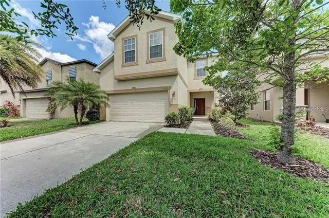 a front view of a house with a yard and a garage