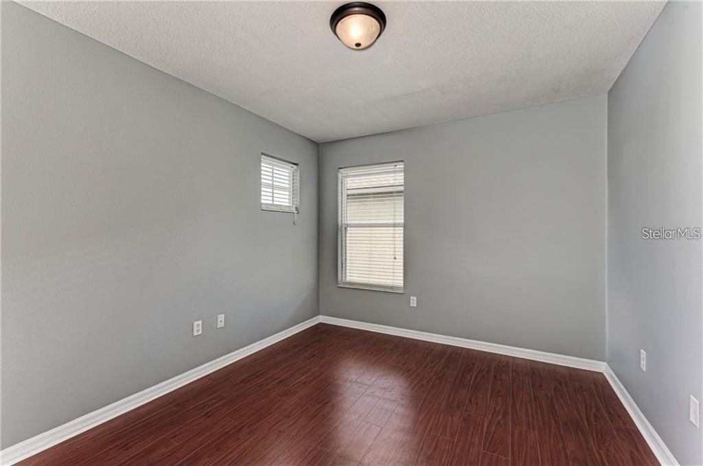 10267 Newminster Loop Ruskin, FL 33573 - Photo 21 of 38 an empty room with wooden floor and windows