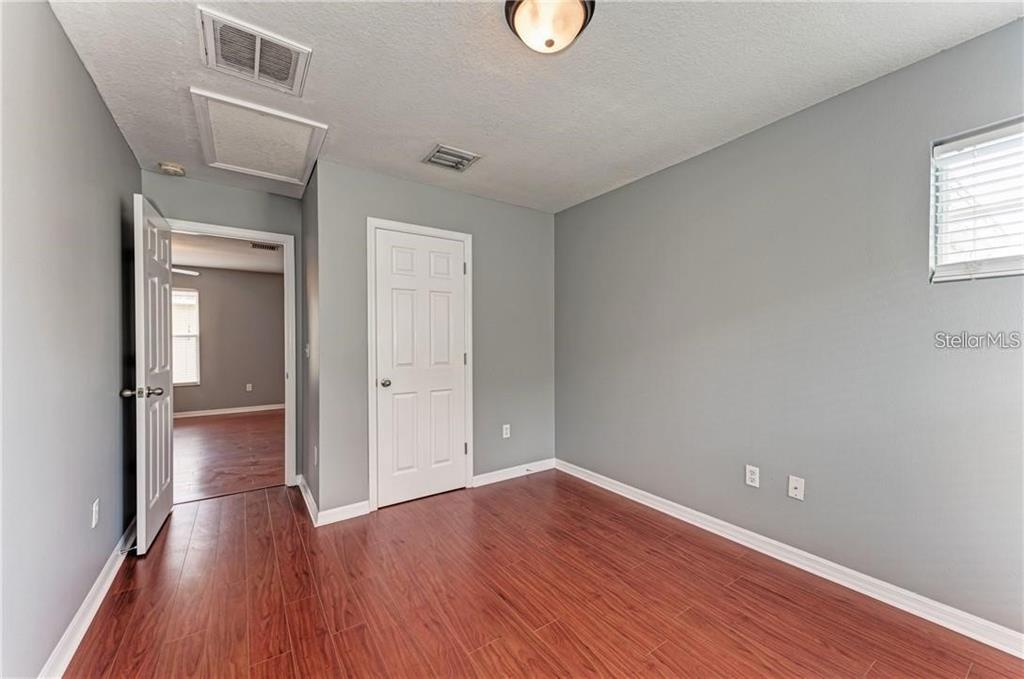 10267 Newminster Loop Ruskin, FL 33573 - Photo 22 of 38 an empty room with wooden floor and windows
