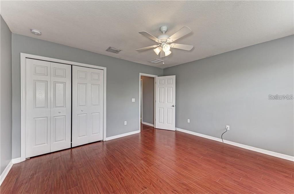 10267 Newminster Loop Ruskin, FL 33573 - Photo 25 of 38 a view of an empty room with wooden floor