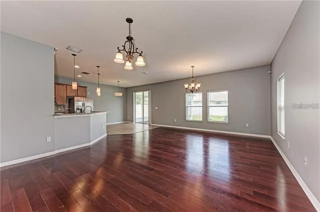 a view of a room with wooden floors and chandelier