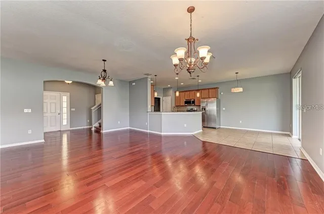a view of a livingroom with a furniture wooden floor and kitchen view