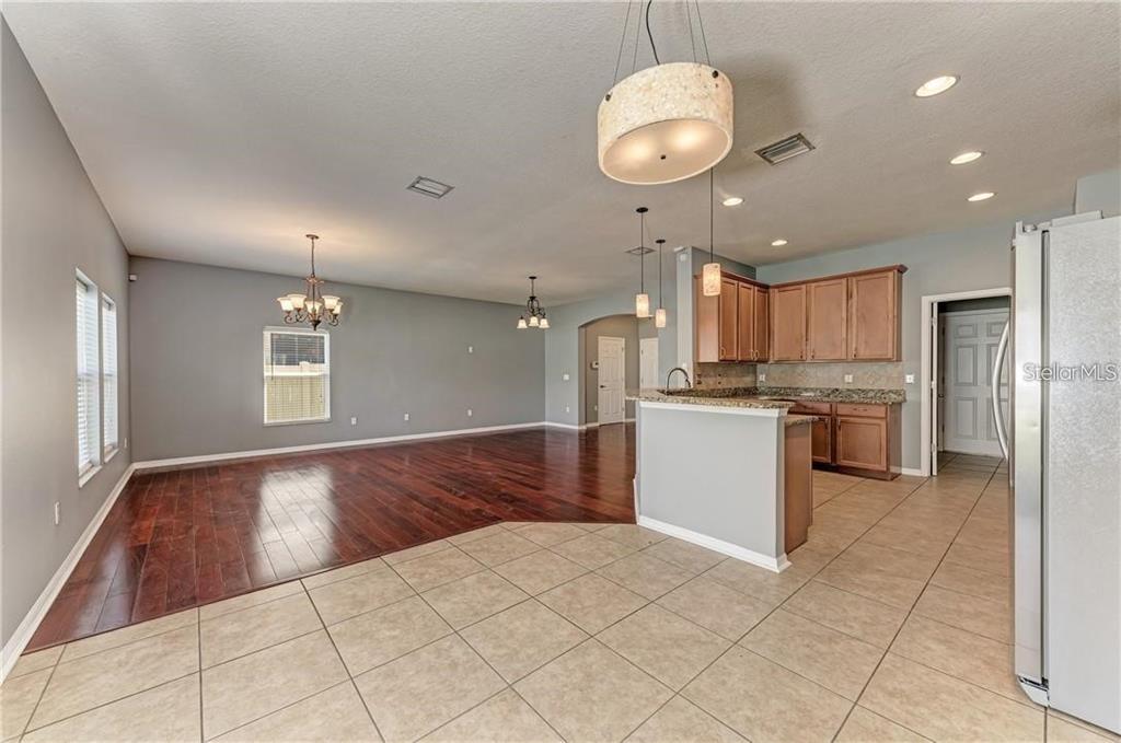 10267 Newminster Loop Ruskin, FL 33573 - Photo 6 of 38 a kitchen with a refrigerator and a stove top oven