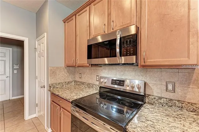a kitchen with stainless steel appliances granite countertop a stove a microwave and cabinets
