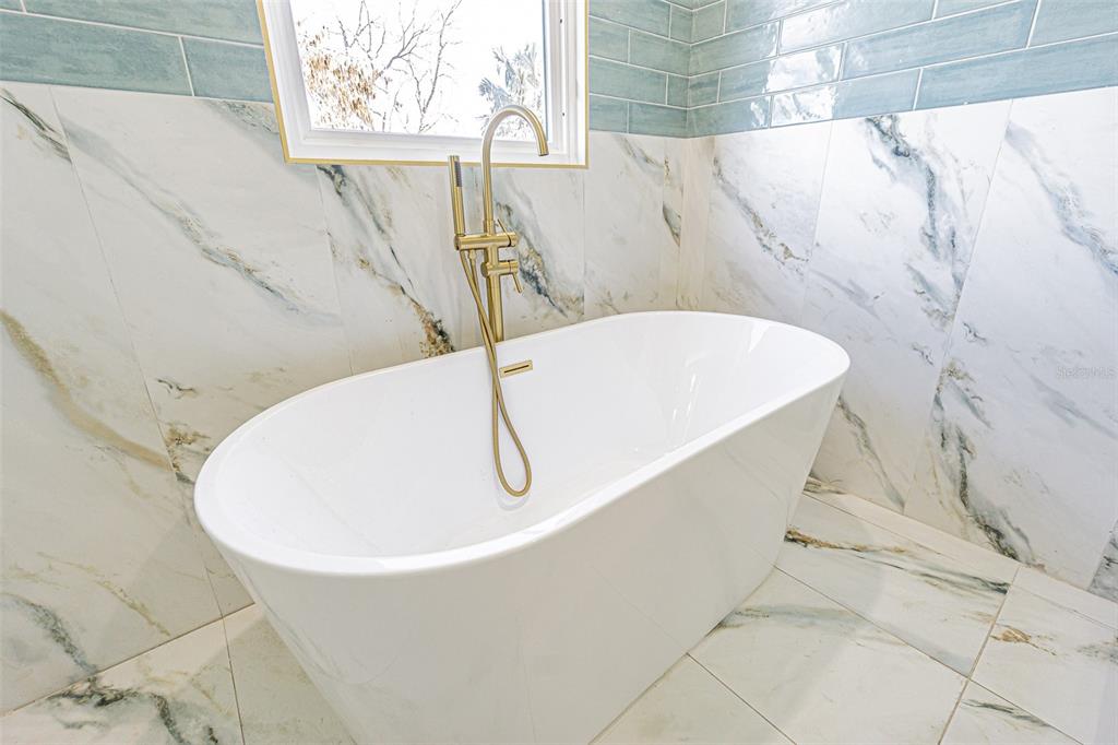 6370 Conniewood Square New Port Richey, FL 34653 - Photo 11 of 27 a bathroom with a bathtub and window