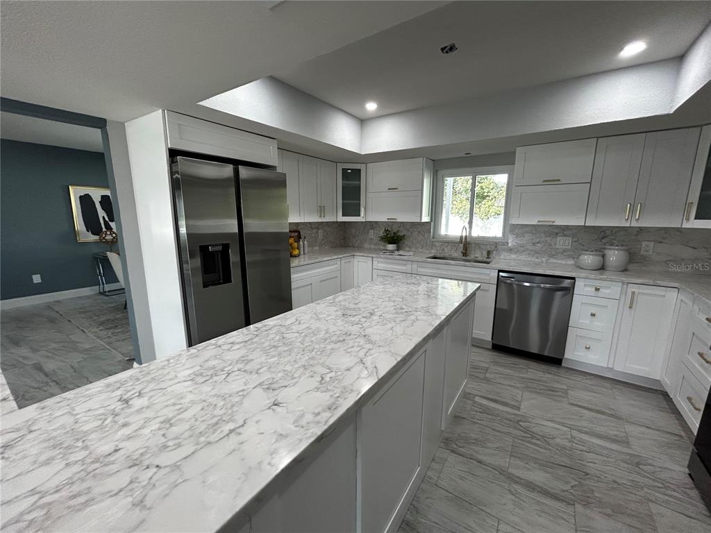 6370 Conniewood Square New Port Richey, FL 34653 - Photo 25 of 27 a large kitchen with granite countertop a large counter top stainless steel appliances and cabinets